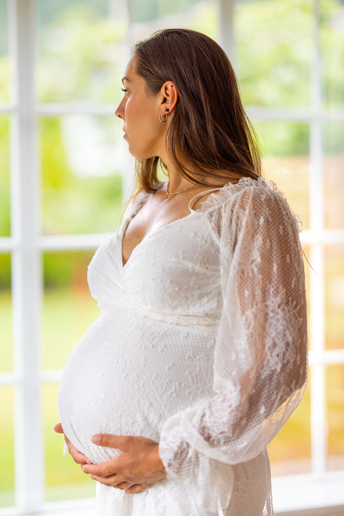 Serene Pregnant Woman Embracing Her Belly Indoors