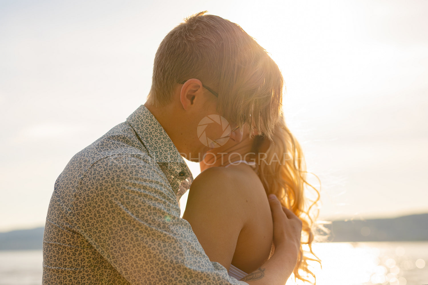 Caring man embrace beautiful girlfriend at the beach