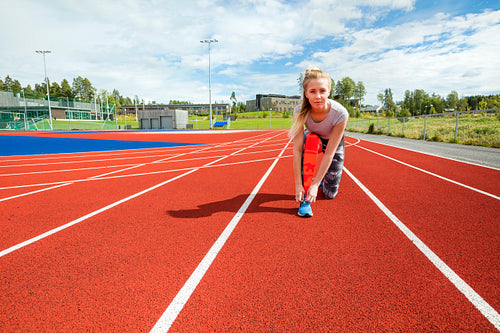 Confident Woman Tying Shoelace On Running Tracks