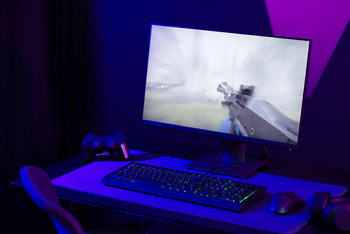 Professional and colorful e-sport gaming studio room with first-person shooter online video game on computer monitor