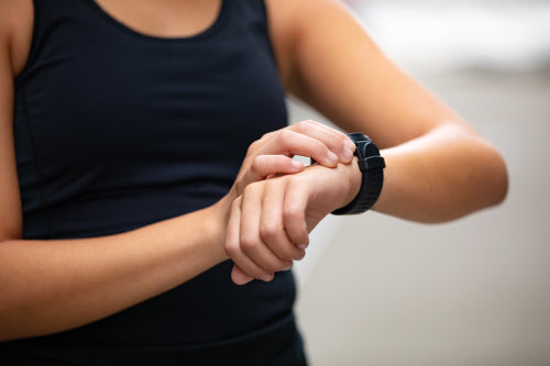 Close-up of woman using fitness smart watch device after running