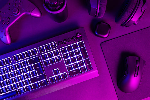 White lit keyboard surrounded by various modern wireless gadgets