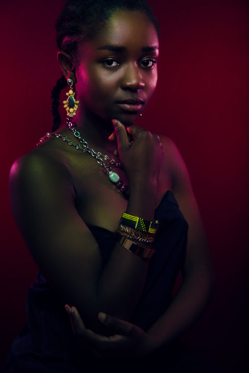 Colorful portrait of sensuous woman wearing jewelry over red background