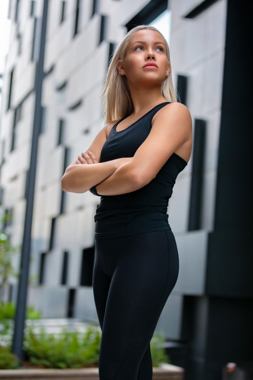 Beautiful Woman Runner Standing Against Futuristic Modern Building In City