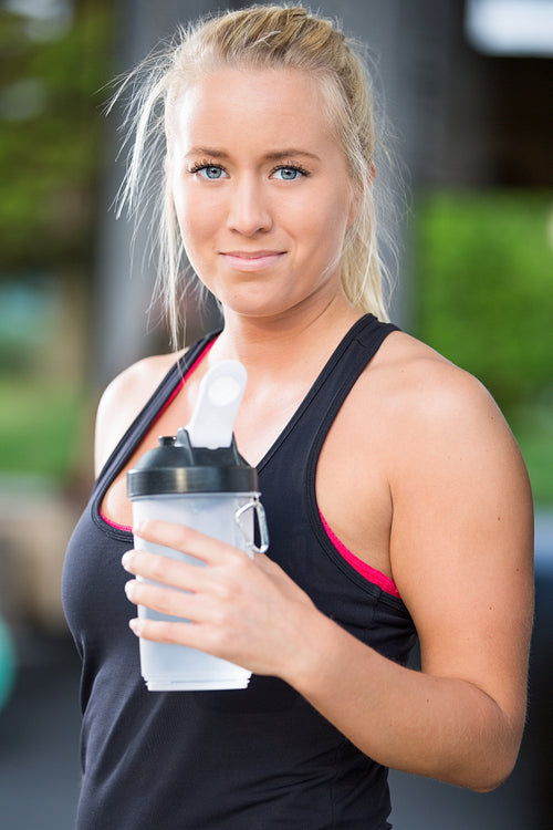 Attractive blonde woman drink water at fitness gym