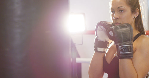 Hard hitting female boxer training in boxing club