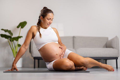 Happy Pregnant Woman Relaxing and Exercising Indoors at Home