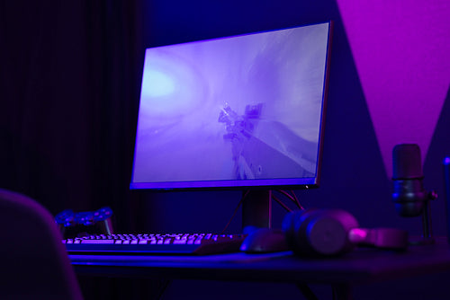 Professional and colorful e-sport gamer room with first-person shooter online video game on computer monitor