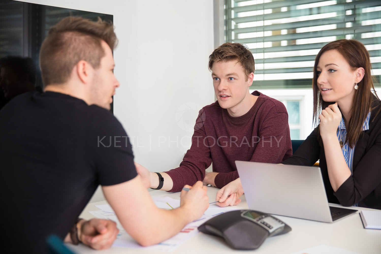Business People Discussing With Colleague At Desk
