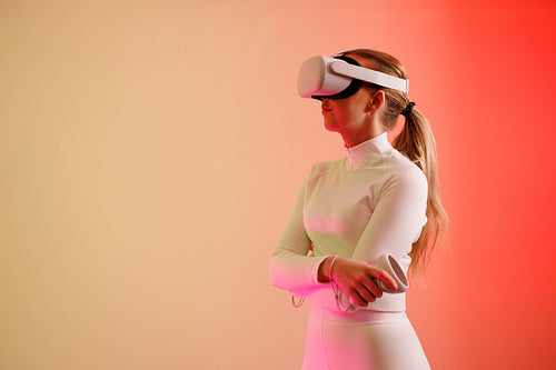 Woman in VR glasses standing with arms crossed