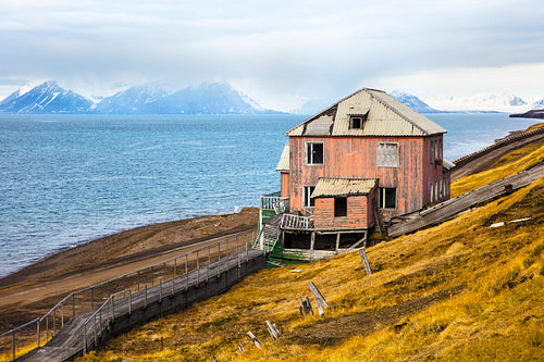 Abandoned house in the harsh arctic nature at summer