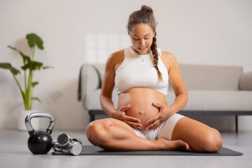 Pregnant Expecting Mother Engaged in Active Fitness Routine in Living Room