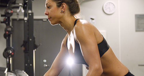 Close-up of dedicated woman training and lifting weights in fitness gym