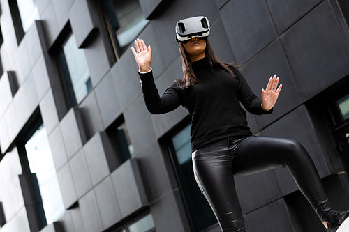 Beautiful Woman Wearing Virtual Reality Glasses And Black Clothes In Futuristic City