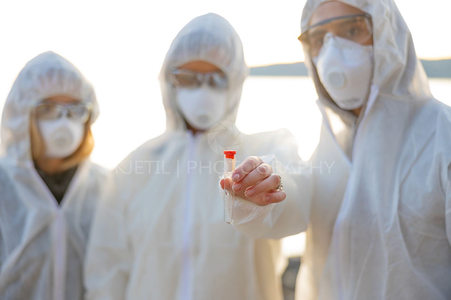 Group of researchers holding water sample at beach