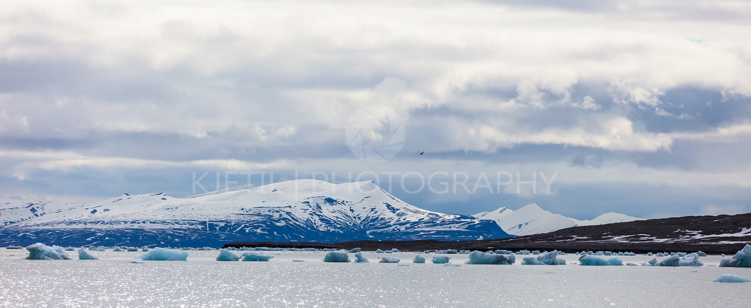 Panorama of floating sea ice in front of snowy mountains in the arctic