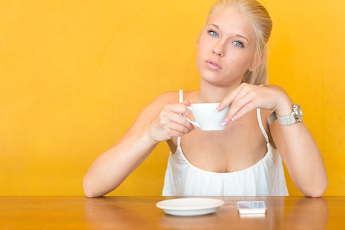 Blonde woman drinks coffee at cafe