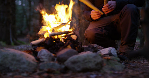 Man lights a campfire outdoors in the forest