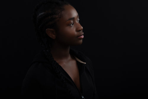 Confident and happy Black Female Model Looking Away Against Black Background