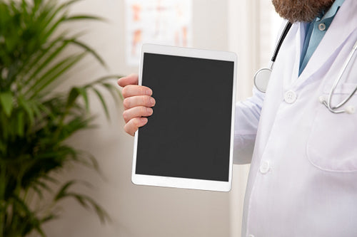 Adult male doctor showing a digital image or report on a tablet
