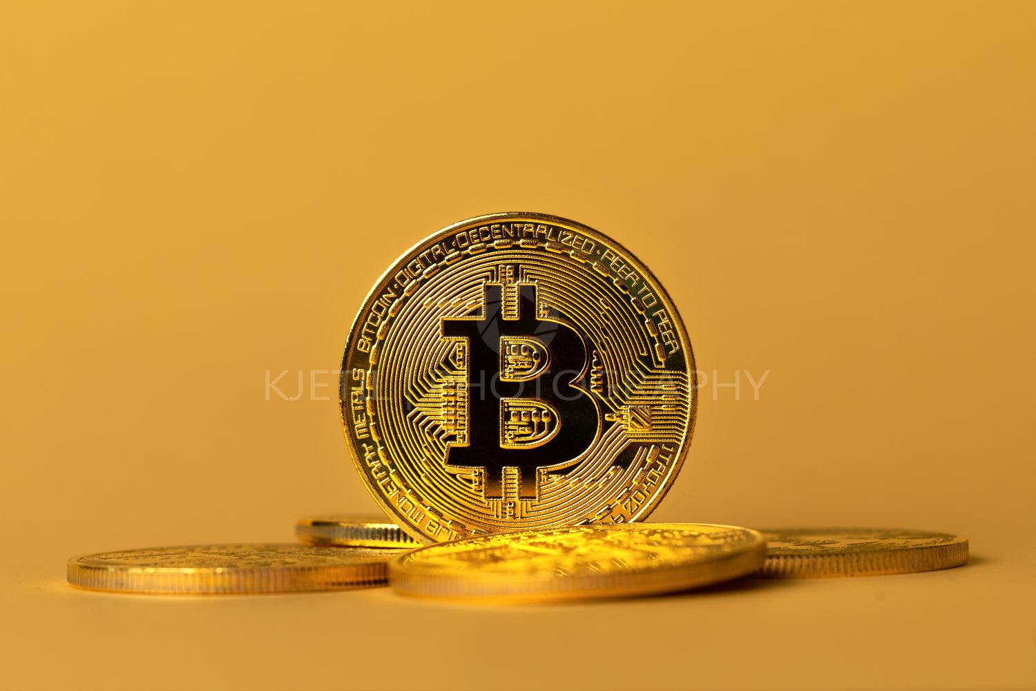 Closeup of gold bitcoins on yellow backgound