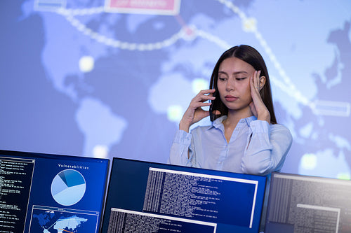 Concerned Female Cybersecurity Manager in Enterprise Cyber Security Operations Center SOC working with a security breach