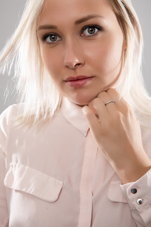 Beautiful female blonde model in shirt holding her hair