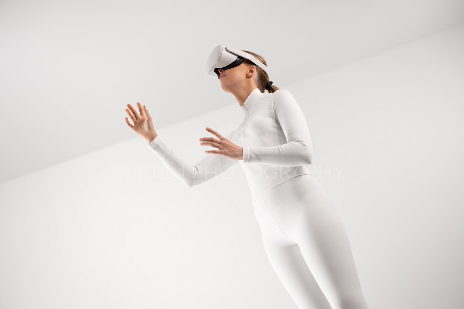 Woman in white suit experiencing virtual reality with VR headset in minimalistic environment