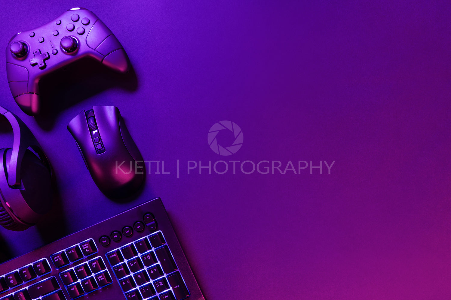 Gaming gadgets on illuminated purple desk