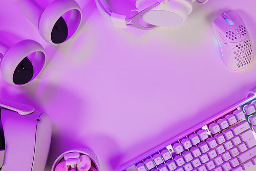 Keyboard with gadgets on illuminated purple desk