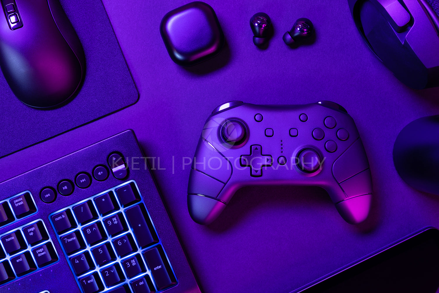 Blue lit keyboard amidst various devices