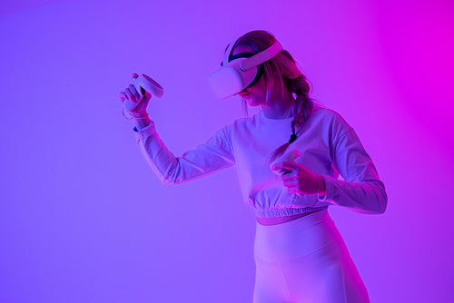 Young woman immersed in a vibrant virtual reality experience with neon lights