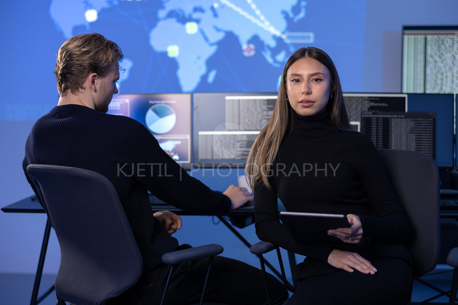 Serious Female Cybersecurity Analyst in large Cyber Security Operation Center SOC handling Threats