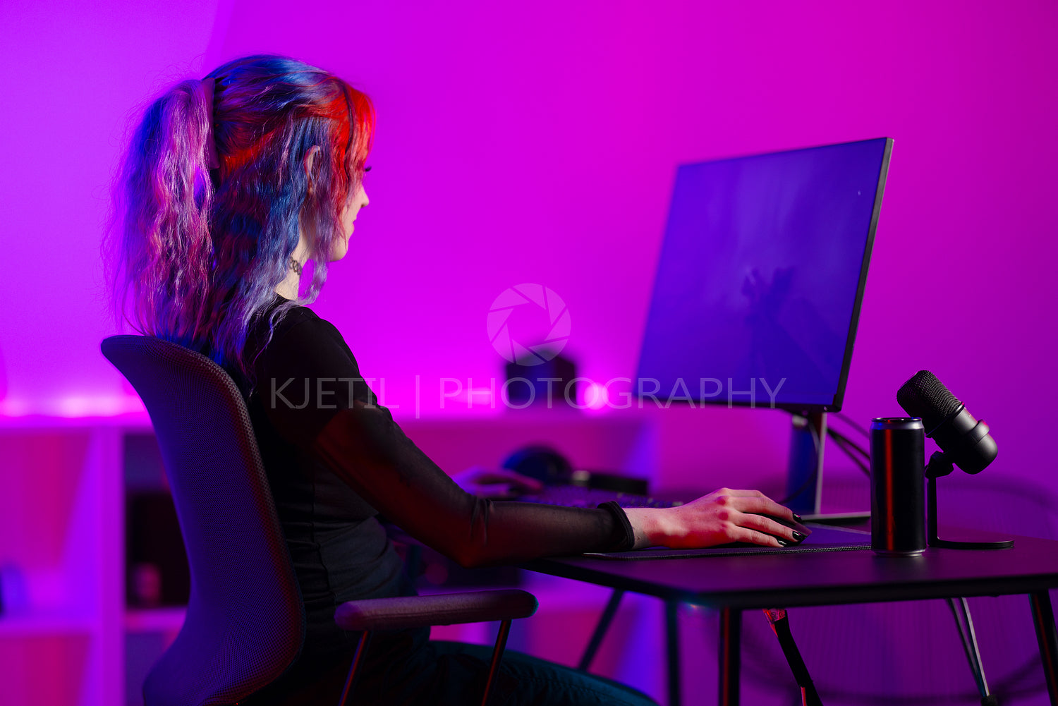 Professional gamer playing video game in colorful room with neon lights