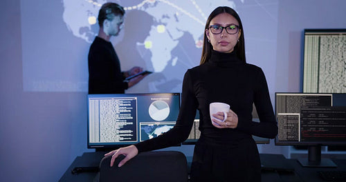 Confident female Cybersecurity Analyst or Manager in large Cyber Security Operations Center SOC handling Threats