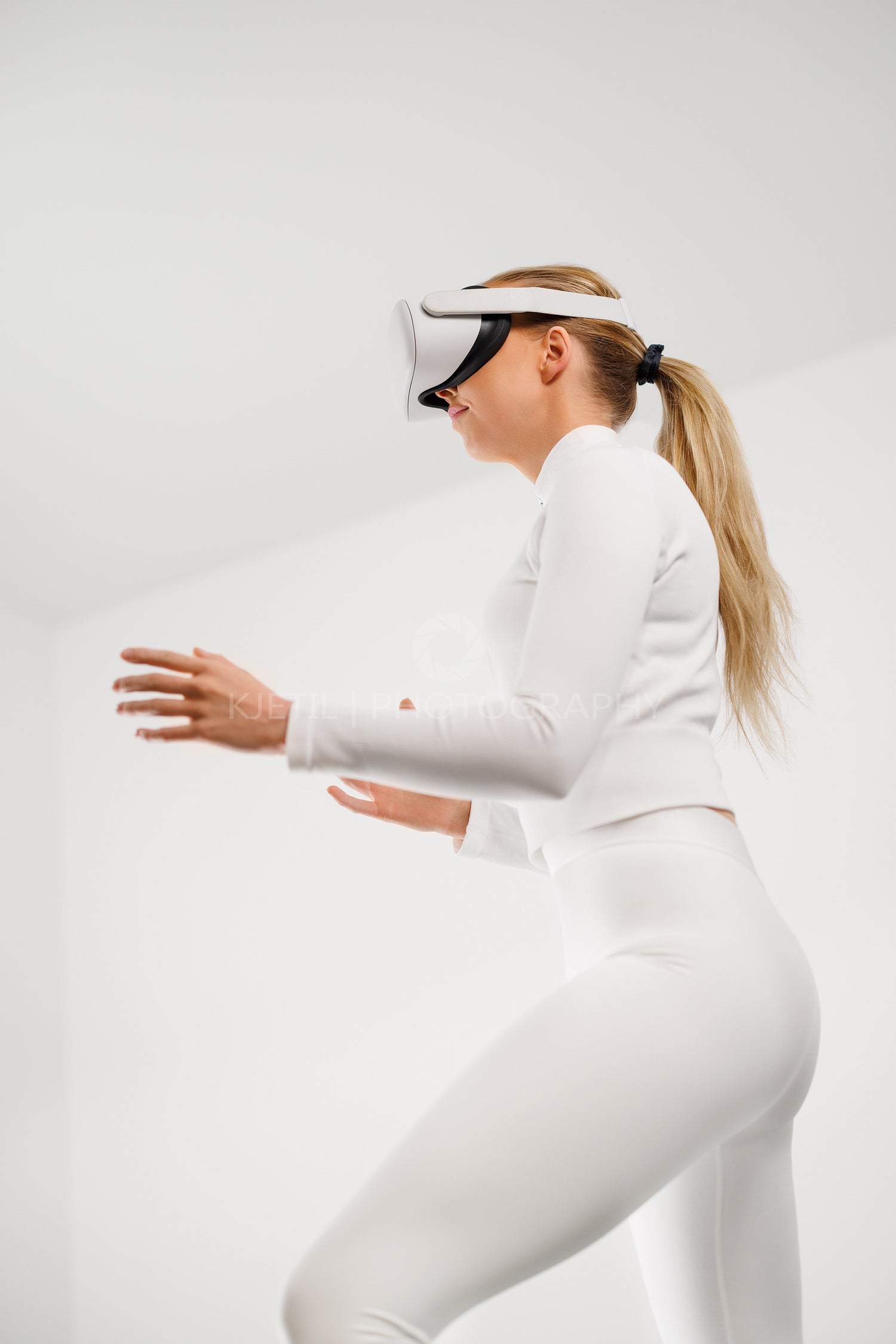 Woman in White Using Virtual Reality Headset in Bright White Room