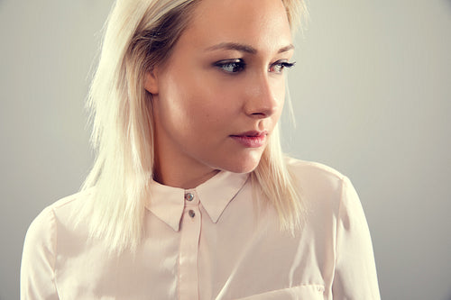 Pensive beautiful female blonde model in shirt looking away from camera