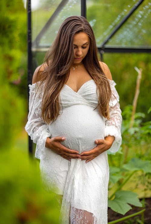 Serene Pregnant Woman Embracing Her Belly in Nature
