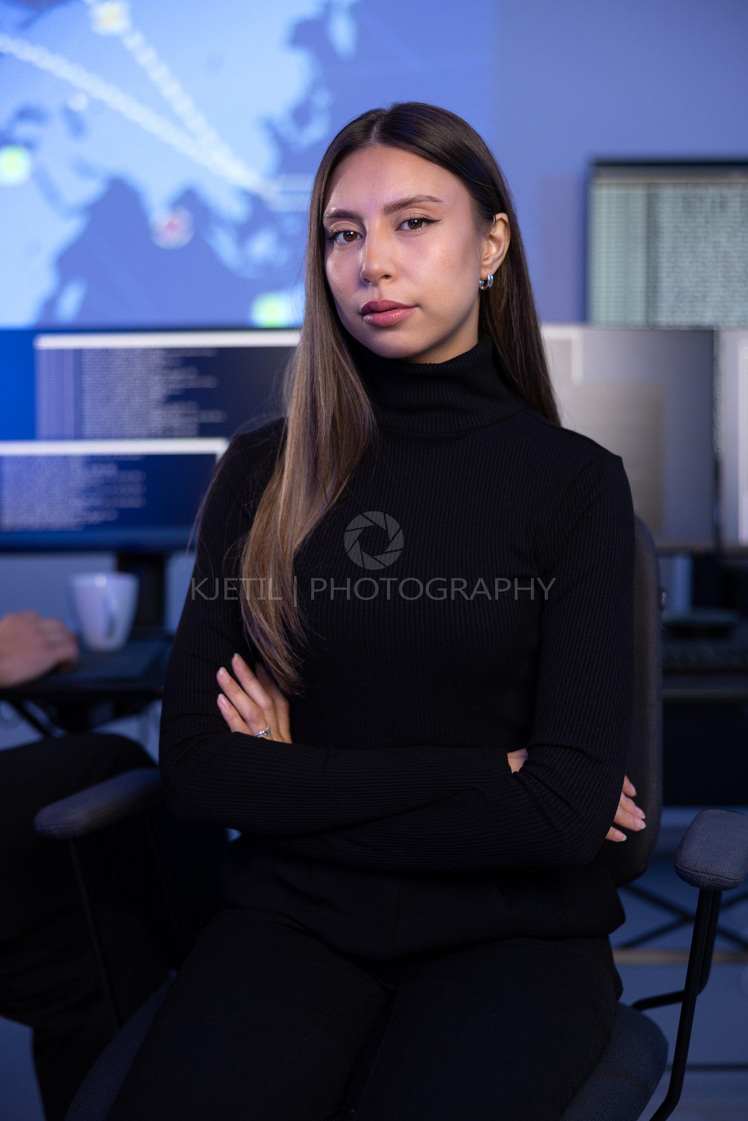 Portrait of a confident female Cybersecurity Analyst or Manager in large Cyber Security Operations Center SOC handling Threats