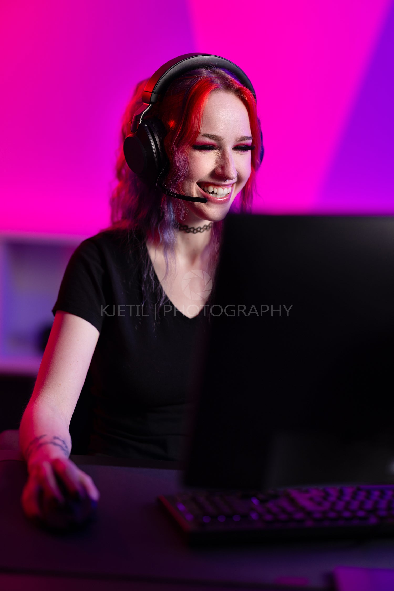 Professional gamer plays enthusiastically in a colorful room with headset and computer setup