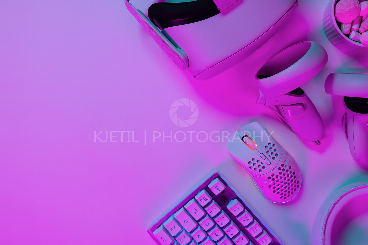 Various modern gaming accessories on pink desk