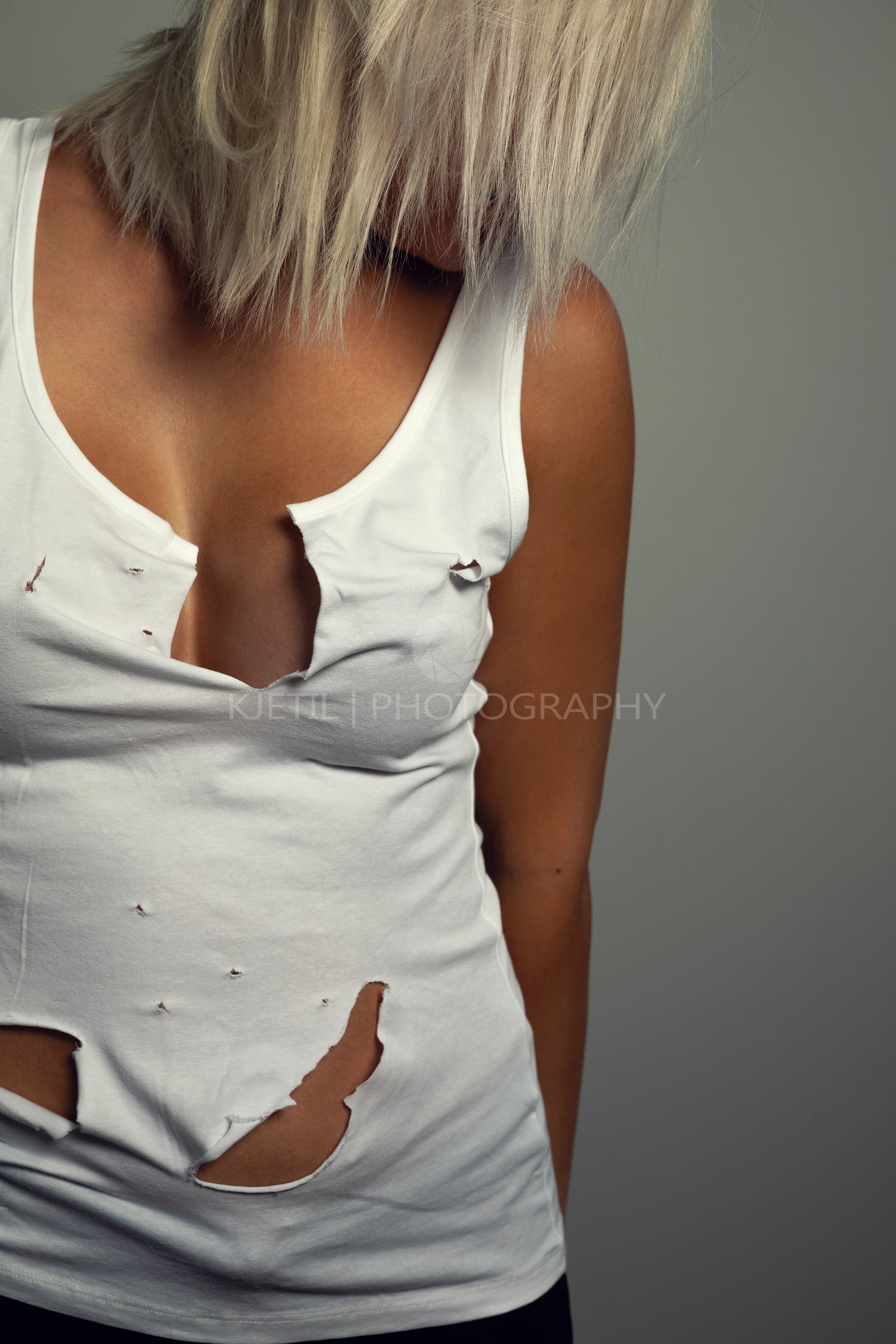 Close-up portrait of beautiful blonde woman with worn holey t-shirt