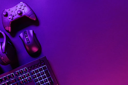 Gaming gadgets on illuminated purple desk