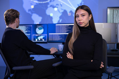 Serious Female Cybersecurity Analyst in large Cyber Security Operation Center SOC handling Threats