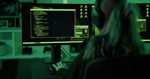 Young cyber security hacker code harmful software to exploit vulnerability in program or system in dark room