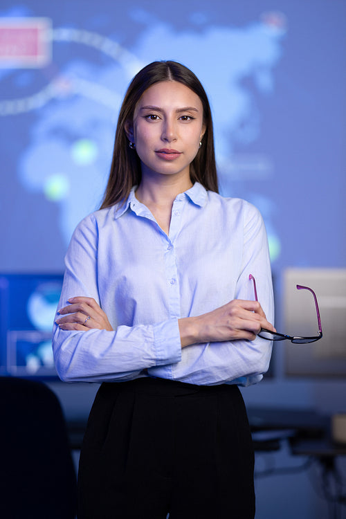 Confident female Cybersecurity Analyst or Manager in large Cyber Security Operations Center SOC handling Threats