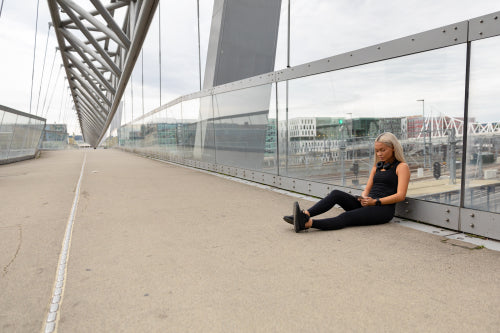 Runner Resting On Bridge After Workout and Check Wokout Performance