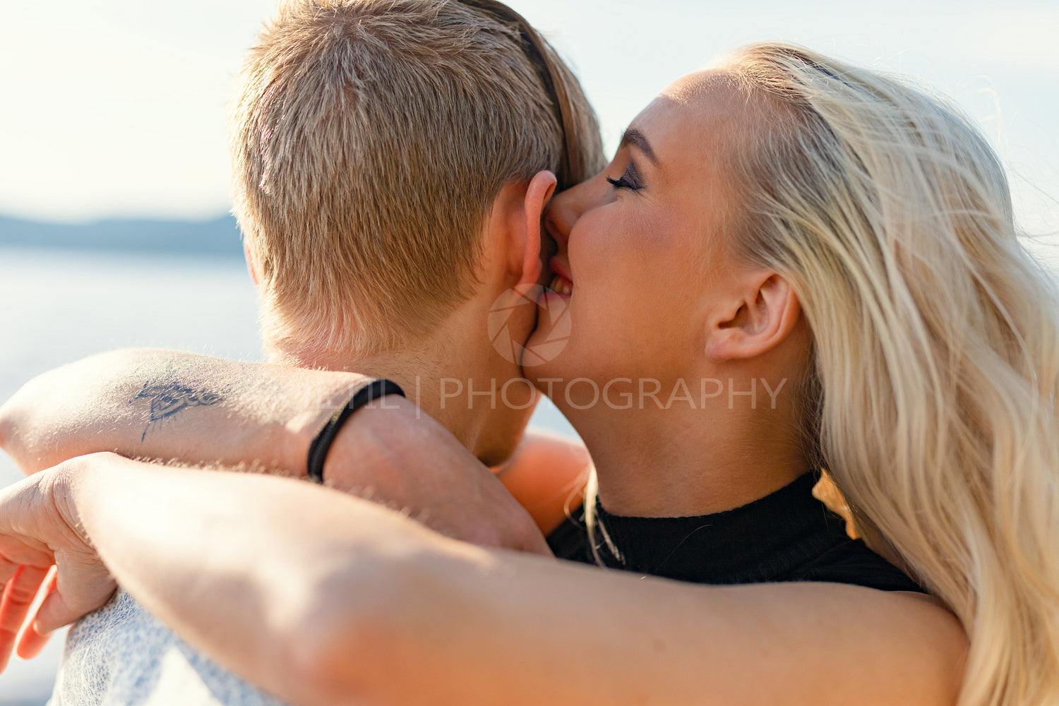 Happy couple in hugging on beach in summer