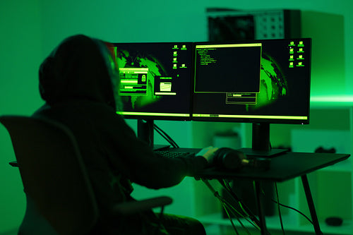 Cyber security hacker code harmful software to exploit vulnerability in program or system in dark room