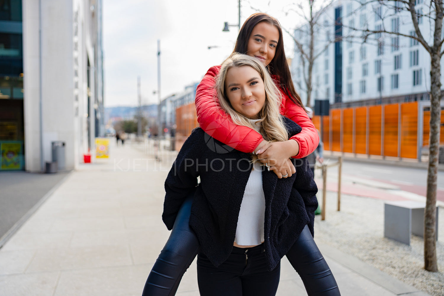 Smiling Female Friends Having Fun and Piggybacking In City Environment